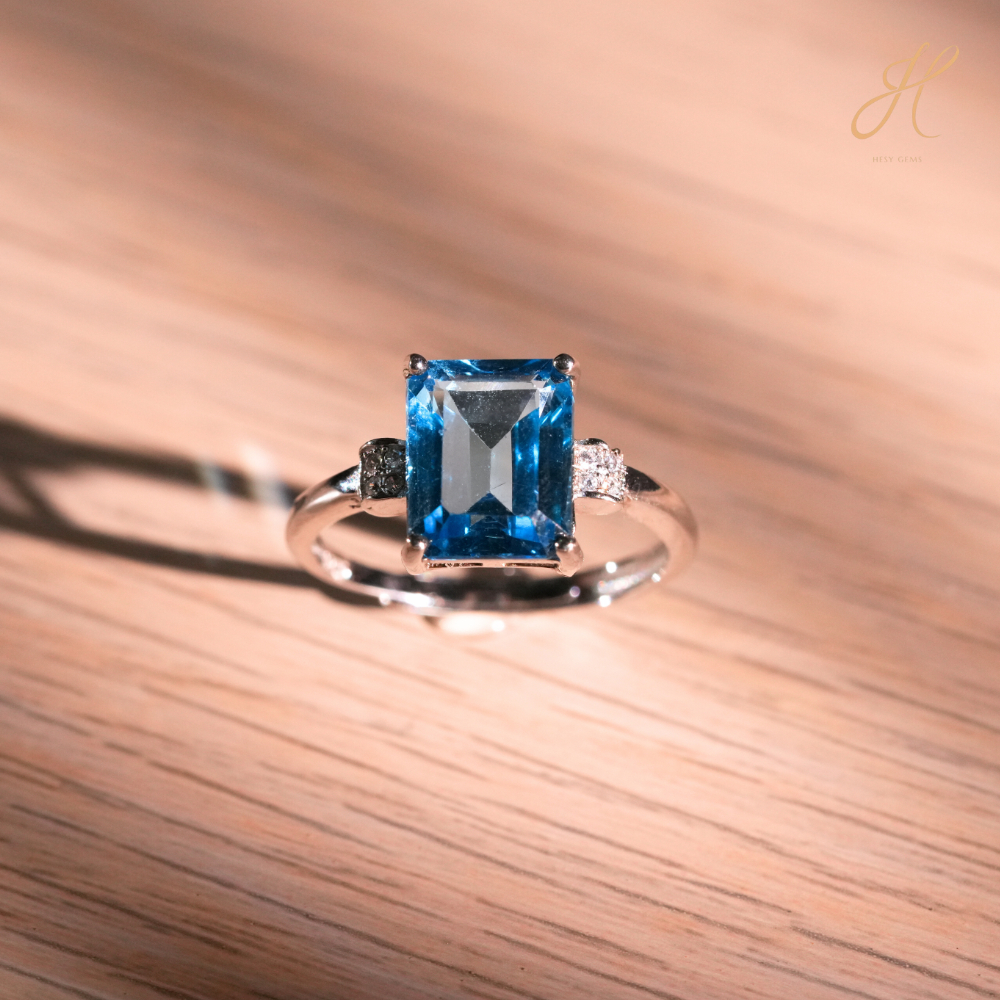 แหวน Swiss Blue Topaz เอมเมอรัลคัท ประดับบ่าข้าง CZ – Swiss Blue Topaz Emerald-Cut Ring with CZ A