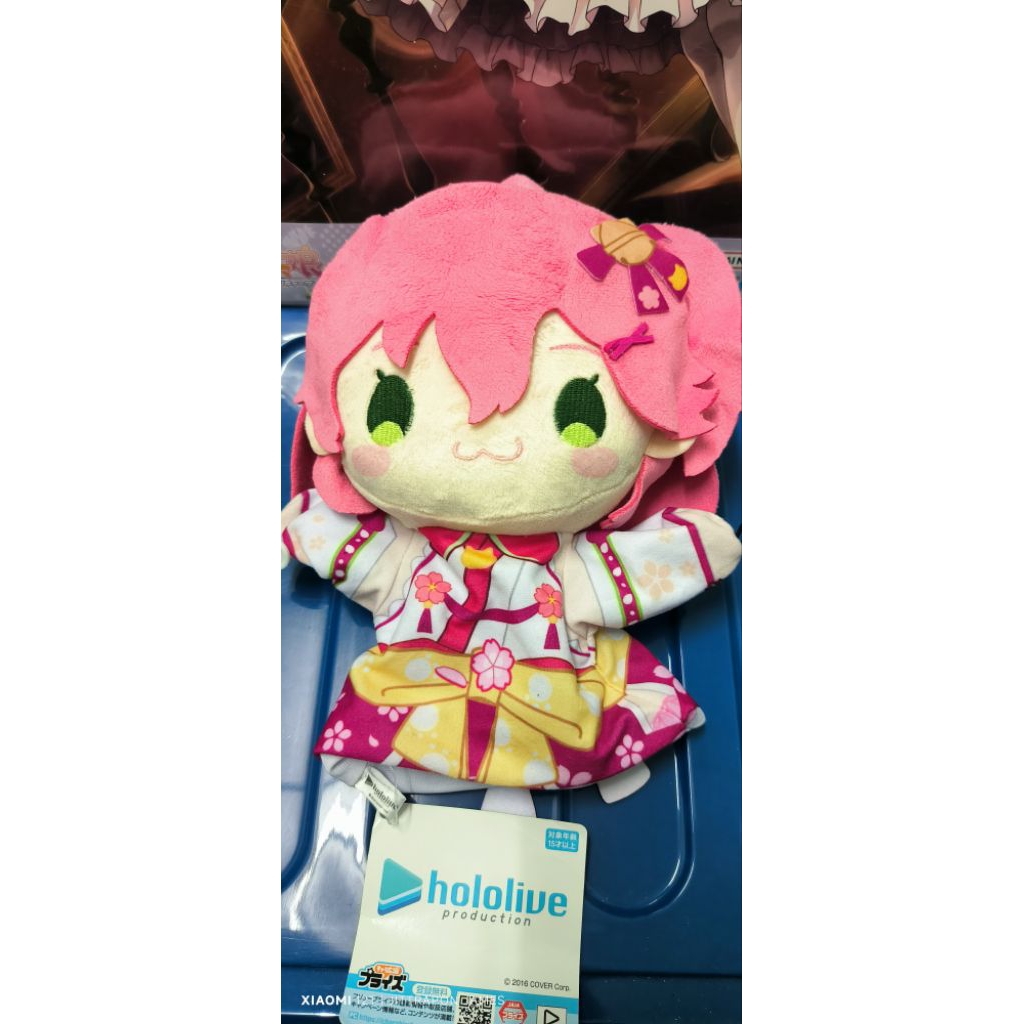 ตุ๊กตาผ้าของ Sakura Miko ซึ่งเป็น(VTuber) จากสังกัด Hololive Production (หุ่นมือ)มือหนึ่งมีป้าย