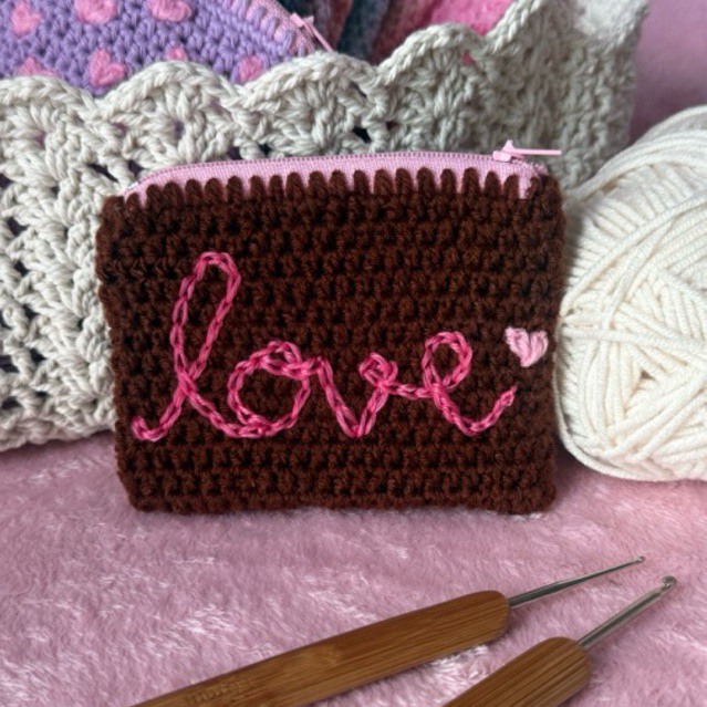 Crochet pouch in chocolate color with embroidery pattern “love/lifeline”