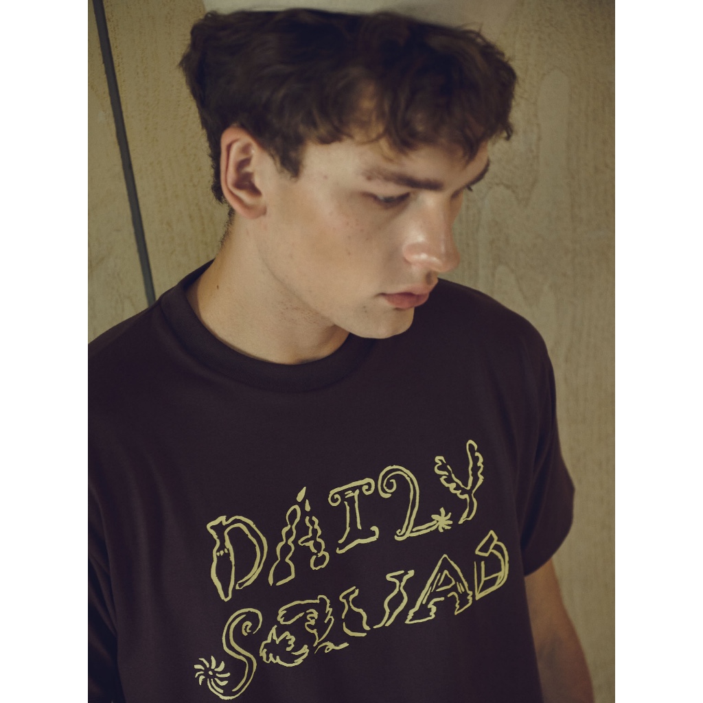 DAILY SQUAD - Artist Tee ดีไซน์เป็นเสื้อโลโก้ที่สะท้อนมุมมองศิลปิน ให้ความรู้สึกเหมือนงานสเก็ตช์มากกว่าตัวอักษรทั่วไป