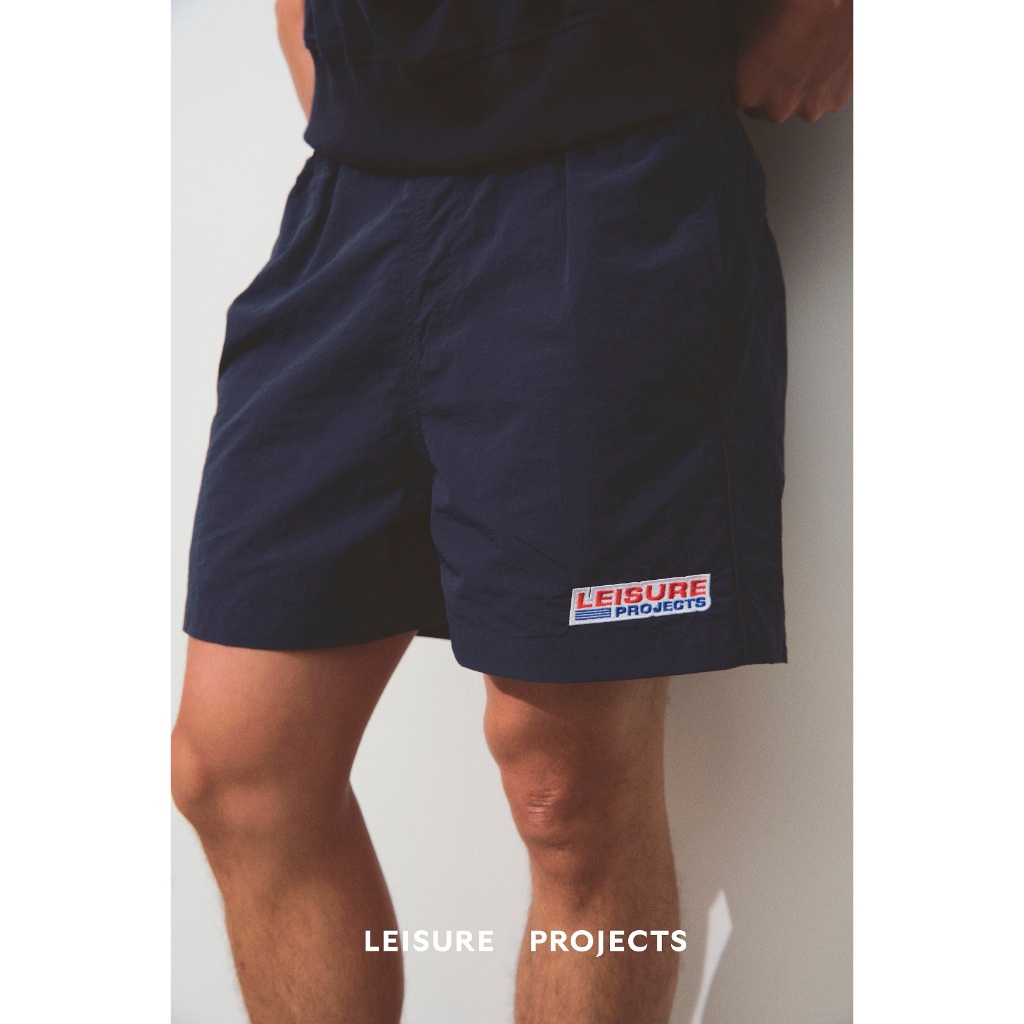 (Leisure Projects) "LEISURE PROJECTS" NYLON SHORTS ดีเทลปัก "Leisure Projects" บริเวณปลายขา
