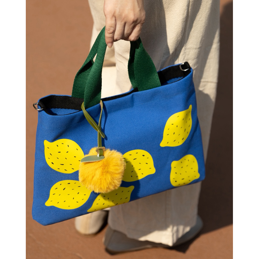 กระเป๋าทรง Mini Tote แบบมีสายสะพายยาว Cross body ผ้าแคนวาสสีน้ำเงินพิมพ์ลายมะนาว พร้อมห้อยน้องมะนาวปอมปอมสีเหลือง