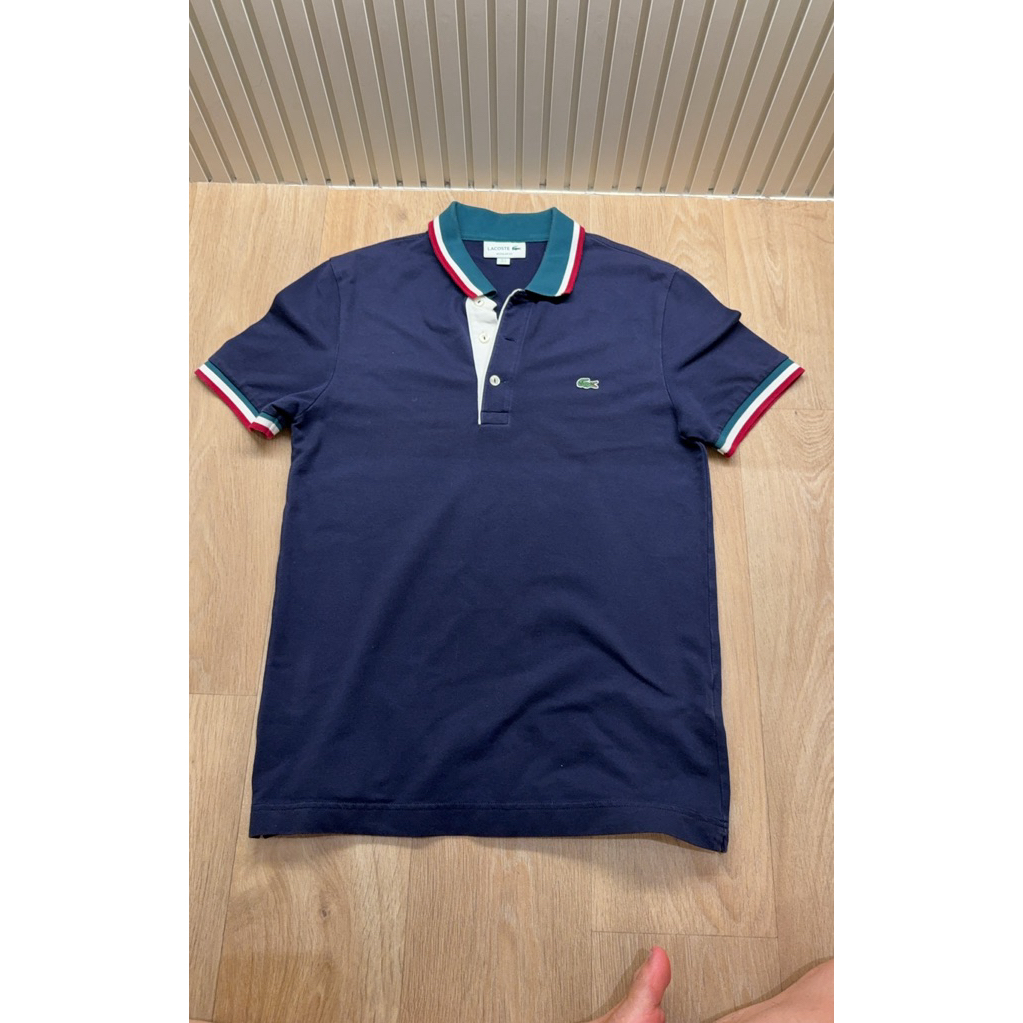 เสื้อเชิ้ตคอกลมแขนสั้นสีกรม Lacoste แท้ Size S อก 46 ซม ยาว 68 ซม ปกเสื้อเขียวขาวแดง สภาพ 95% ยังใหม