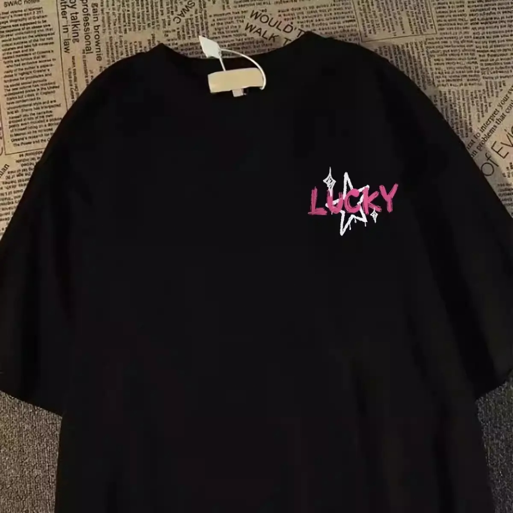 เสื้อยืดลายดาวหยดสีขาว ตัวอักษรแปรงสีชมพู LUCKY NICE พิมพ์หลังเต็ม สีดำ ผ้าฝ้าย 200GSM ทรงโอเวอร์ไซซ์ สไตล์กราฟฟิตีหวานเ