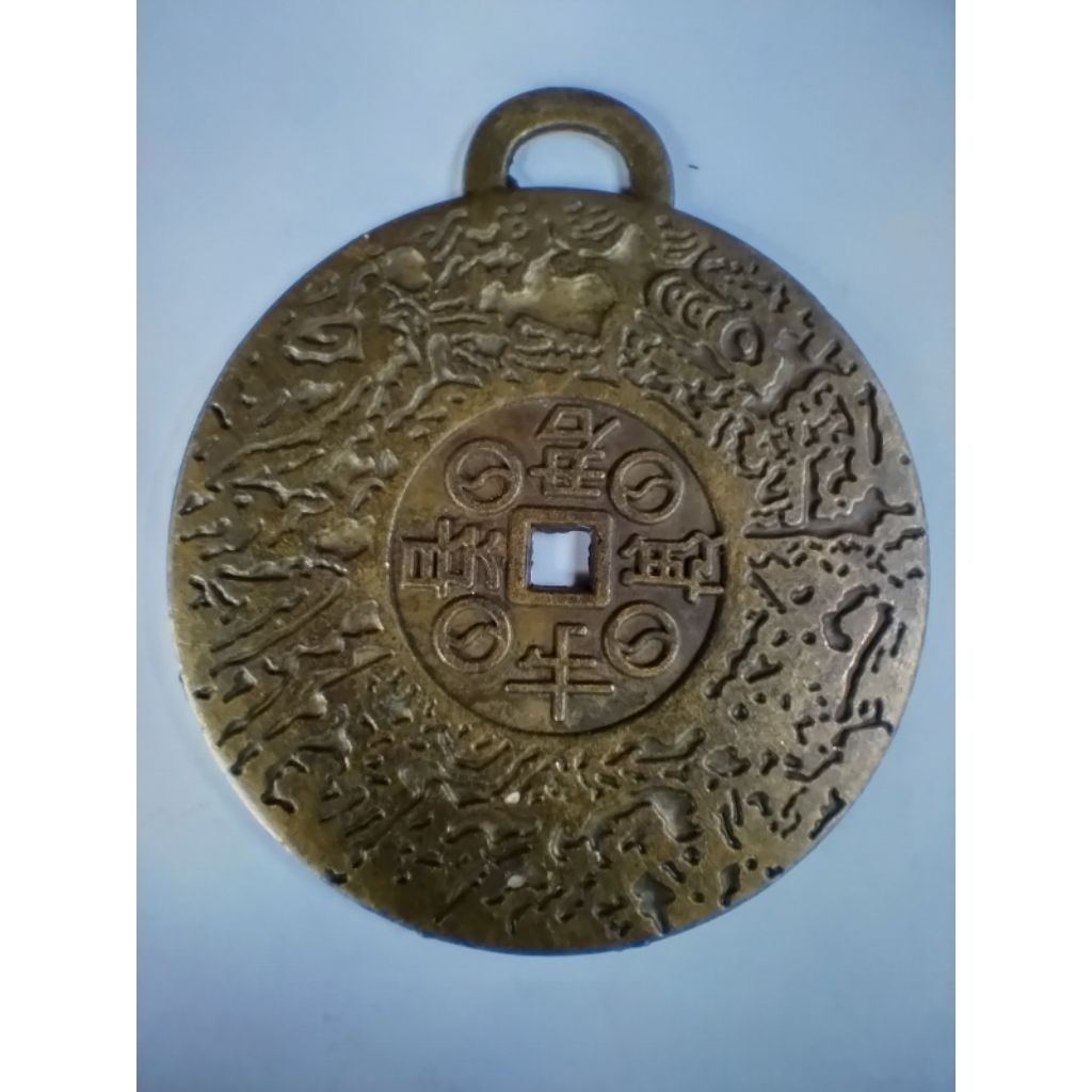 วัตถุในภาพคือเครื่องรางนำโชค "Money Amulet" ซึ่งเป็นเหรียญนำโชคจากทิเบตที่ผ่านการปลุกเสกโดยพระลามะ 