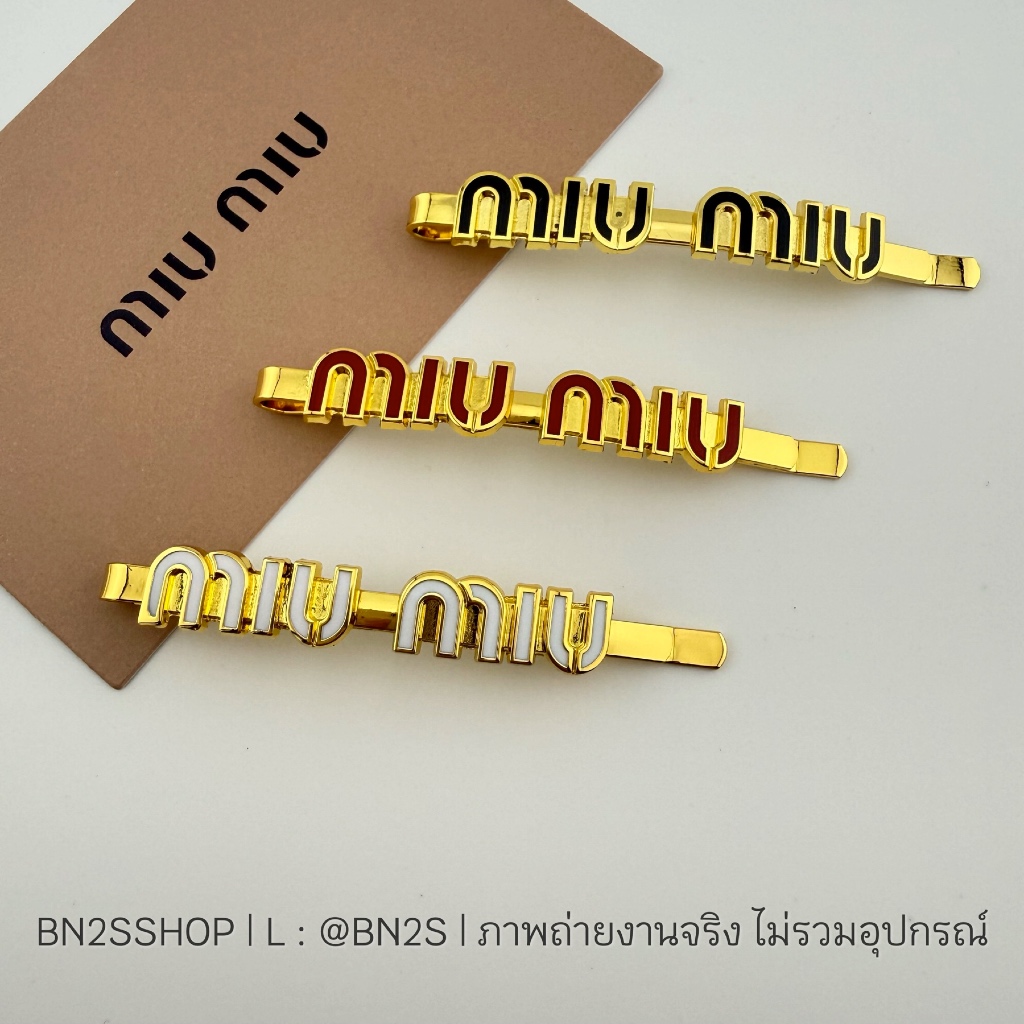 กิ๊บสไลด์ สีทอง ประดับโลโก้ M สีแดง ขาว ดำ งานปั๊มแบรนด์ด้านหลัง