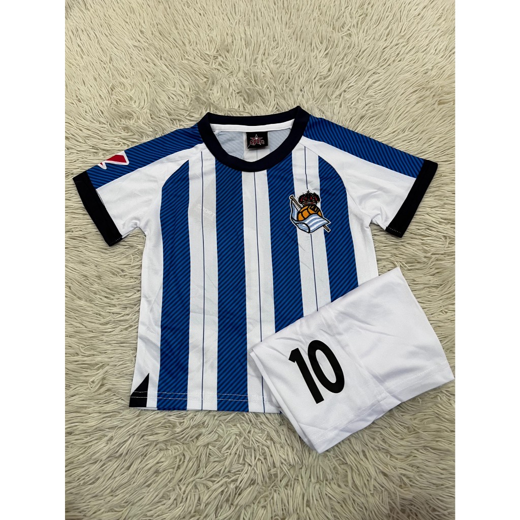 เสื้อฟุตบอลเด็กชุดเหย้าของสโมสรฟุตบอลเรอัล โซเซียดัด ปี2025-2026 ใหม่ล่าสุด เสื้อ+กางเกง