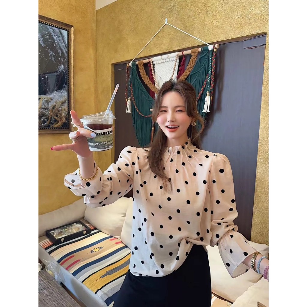 เสื้อแขนยาว ทรงคอปีน ผ้าชีฟอง ช่วงไหล่ยกพองเล็กน้อย ปลายแขนจั๊มระบาย ลายจุดสีดำบนพื้นสีครีมเบจ (Belle Dot)
