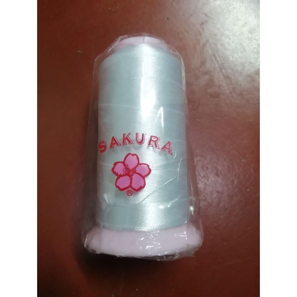 ไหมปักคอมโพลีสีขาว หลอดใหญ่ยี่ห้อซากุระ ไหมเหนียว ปักคอม สีขาว ใช้ไฮเตอร์ได้ ยี่ห้อซากุระหลอดใหญ่ เบอร์ 6003