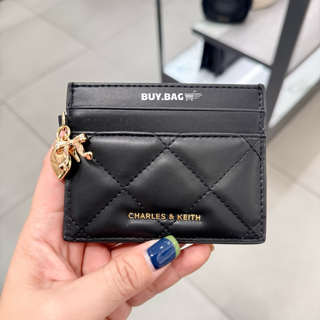 CHARLES & KEITH ( ใช้โค้ดลด30% ) กระเป๋าสตางค์ลายควิลท์ฝาปิดโค้งประดับชาร์มรูปหัวใจโบว์รุ่น Arrietty
