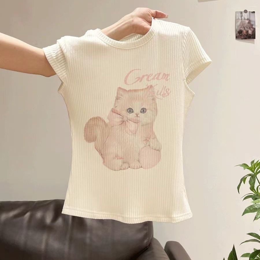 เสื้อยืดคอกลม แฟชั่น ผ้าถักร่องสีครีมนมวานิลลา สุดละมุนตา พิมพ์สกรีนลายกราฟิกเจ้าเหมียวขนฟู ตัวจิ๋วสวมโบว์สีชมพูพาสเทล