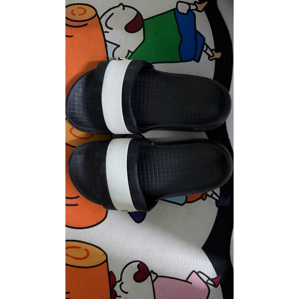 รองเท้าแตะ Lacoste สีดำสลับขาวด้วยโลโก้จระเข้สีทองขนาดเล็กที่ติดอยู่ด้านข้างสายคาด 37-38 ใส่ไม่กี่คร