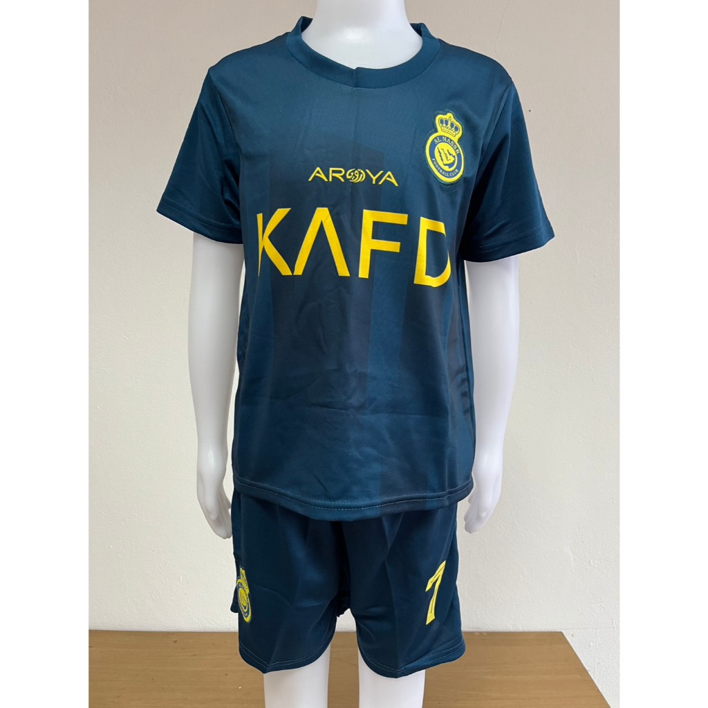 ชุดวอร์มฟุตบอลสำหรับเด็กของสโมสร Al-Nassr FC มีหมายเลข 7 และชื่อของโรนัลโด ประกอบด้วยเสื้อและกางเกง 
