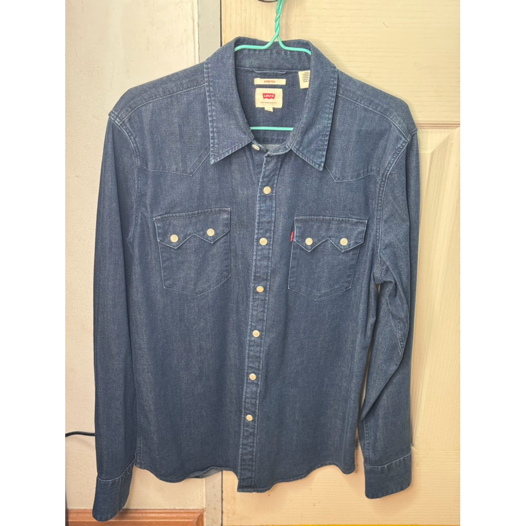 เสื้อเชิ้ตยีนส์ Levi’s กระเป๋าฟันเลื่อย กระดุมมุก สไตล์เรียบๆ (ของแท้จากช็อป100%) สภาพดี สีเข้มไม่มี
