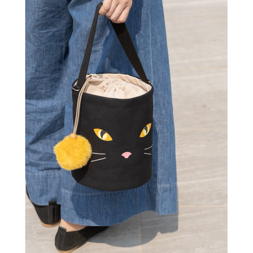 Cat Eyes Bucket กระเป๋า Bucket ผ้าแคนวาสสีดำ พิมพ์ลายตาแมว พร้อมปอมปอมสีเหลือง
