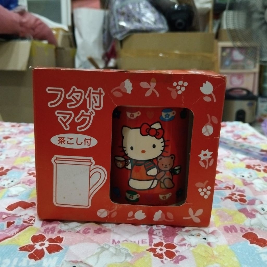 แก้วน้ำพร้อมฝาปิดและที่กรองชาลาย Hello Kitty ซึ่งจัดเป็นของใช้ในบ้านหรือของสะสม