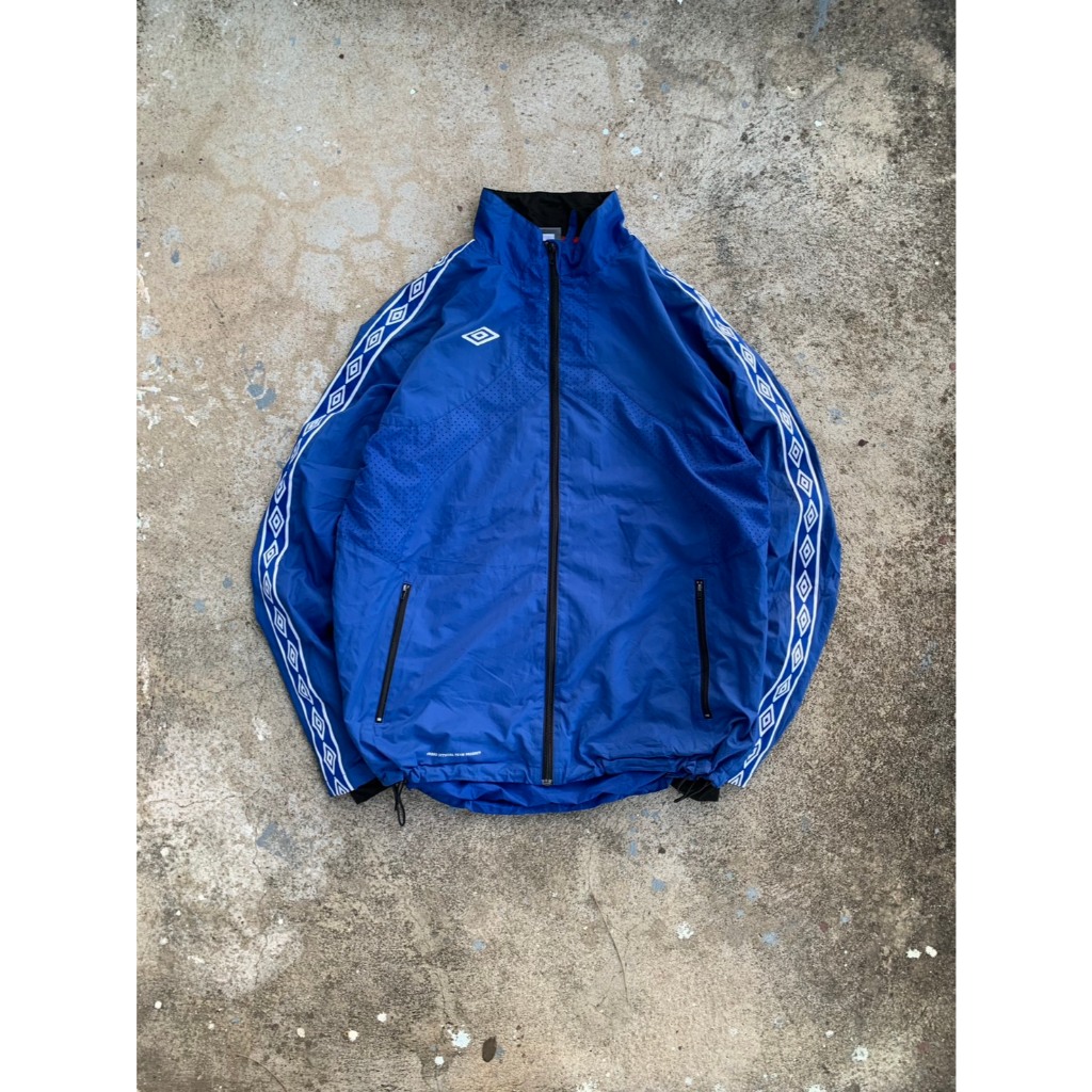 แจ็คเก็ตอัมโบรผ้าร่มแขนแถบสีน้ำเงิน Umbro Jacket Junior Soccer/Futsal Full Zip The Third [9-49umbro]