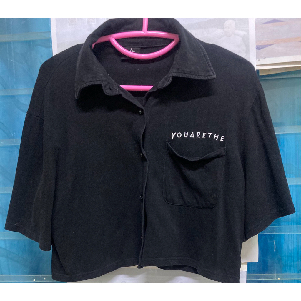 เสื้อครอปคอปกแขนสั้นสีดำจากแบรนด์ URTHE รุ่น CANT CROP ปักข้อความ "YOUARETHE" บนกระเป๋าเสื้อ.อก20-22