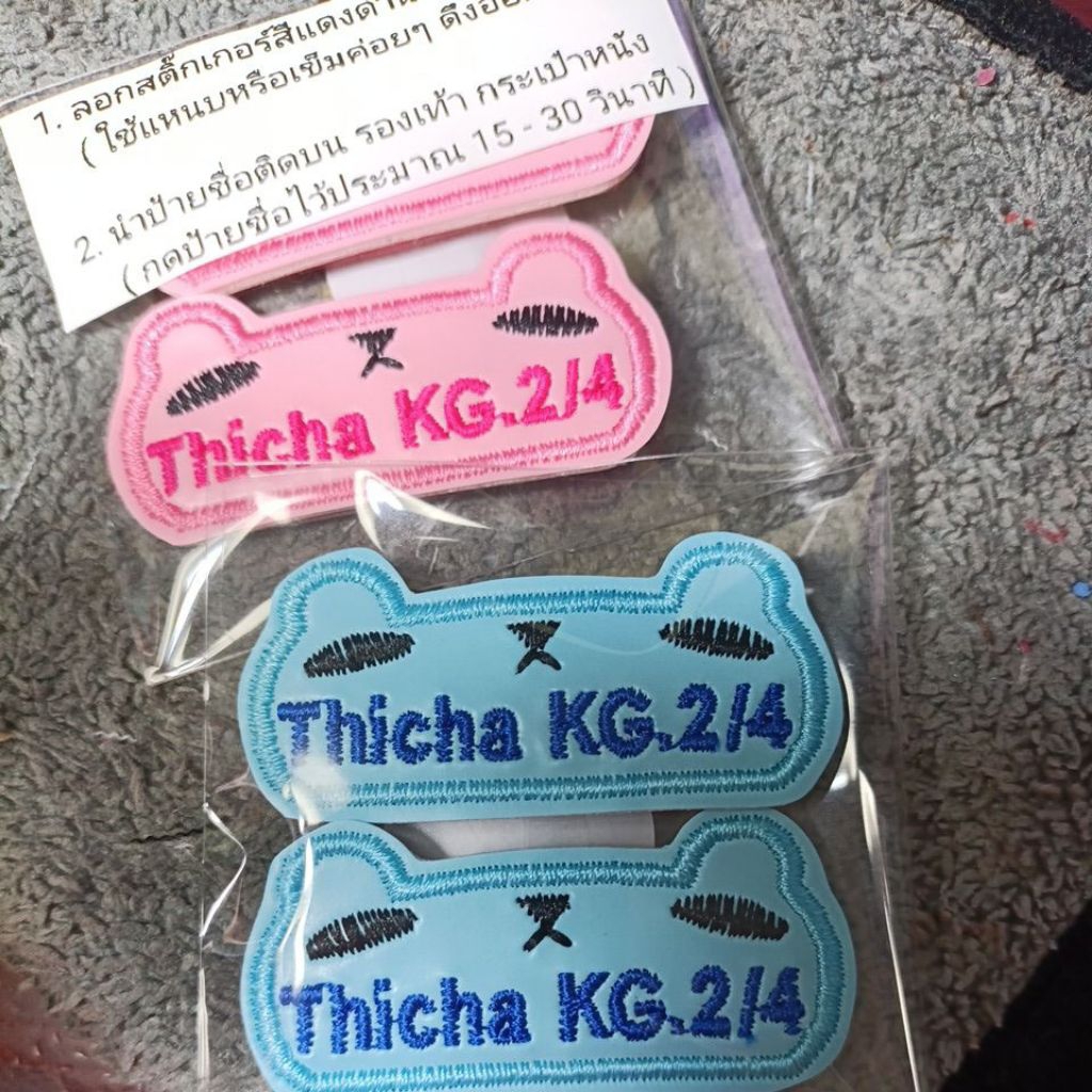 ป้ายชื่อติดรองเท้าแบบกาว 3M พื้นสีชมพูและพื้นสีฟ้าอ่อน ปักชื่อ thicha