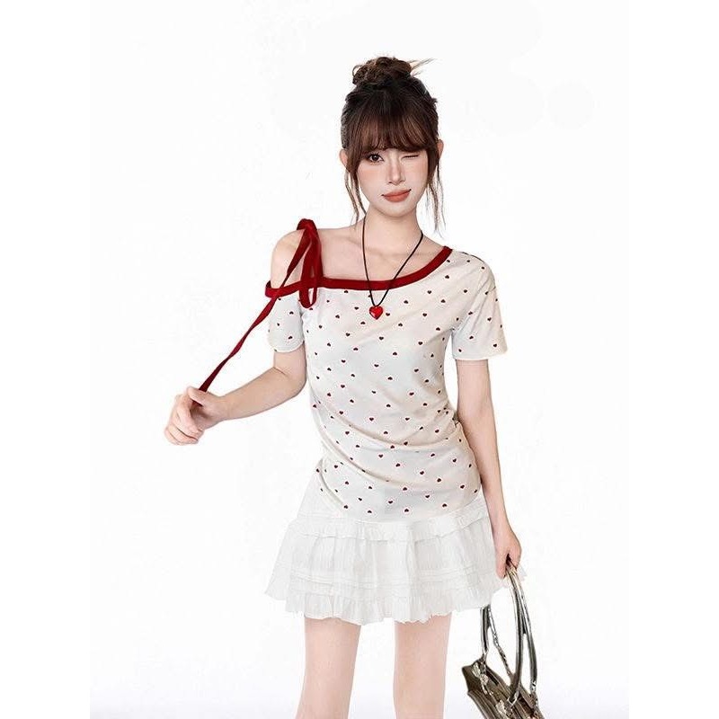 เสื้อปาดไหล่ข้างเดียวลายหัวใจมินิสีแดงสุดจึ้งบนพื้นผ้าสีขาวนวลตาเพิ่มความโดดเด่นด้วยการกุ๊นขอบแดงหนาเน้นดีไซน์คอเฉียง