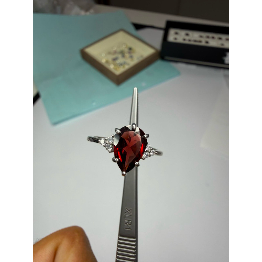 Silver with diamonds and garnet stone.