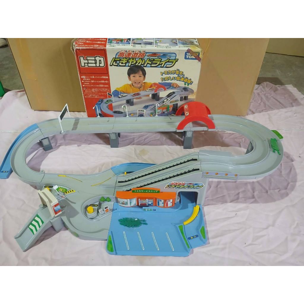ชุดรางรถ Tomica Expressway Nigiriya Drive (トミカ 高速道路 にぎやかドライブ) เป็นชุดรางรถของเล่นสำหรับรถเหล็ก Tomic
