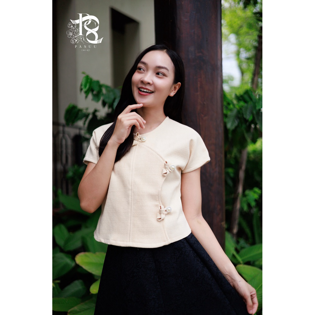 เสื้อพื้นเมือง คอกลมไหล่เลย มอบลุคเรียบร้อยละมุนตา เพิ่มดีเทลความลัคชูกด้วยระดุมมุก และงานโบว์แฮนด์เมด ดูแพงและมีเสน่ห์