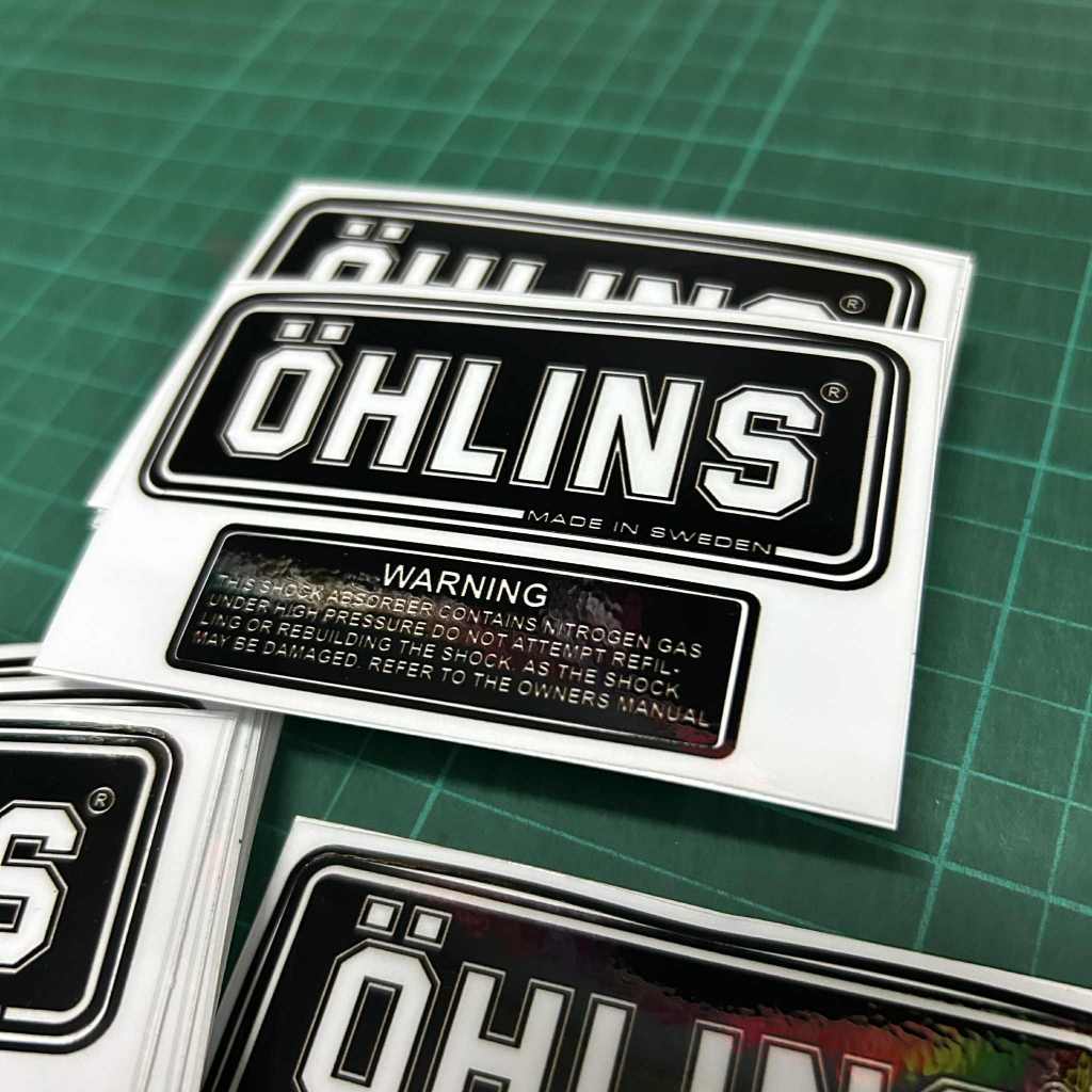 สติกเกอร์ โอลิน Ohlins สำหรับแปะกระป๋องแก๊สโช๊คหลังโอลินหรือเพื่อความสวยงาม ตัวใส พื้นดำ