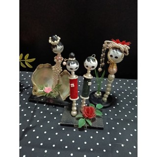 ตุ๊กตาโคเคชิ (Kokeshi) ประดับด้วยไข่มุกและเปลือกหอย ซึ่งเป็น…