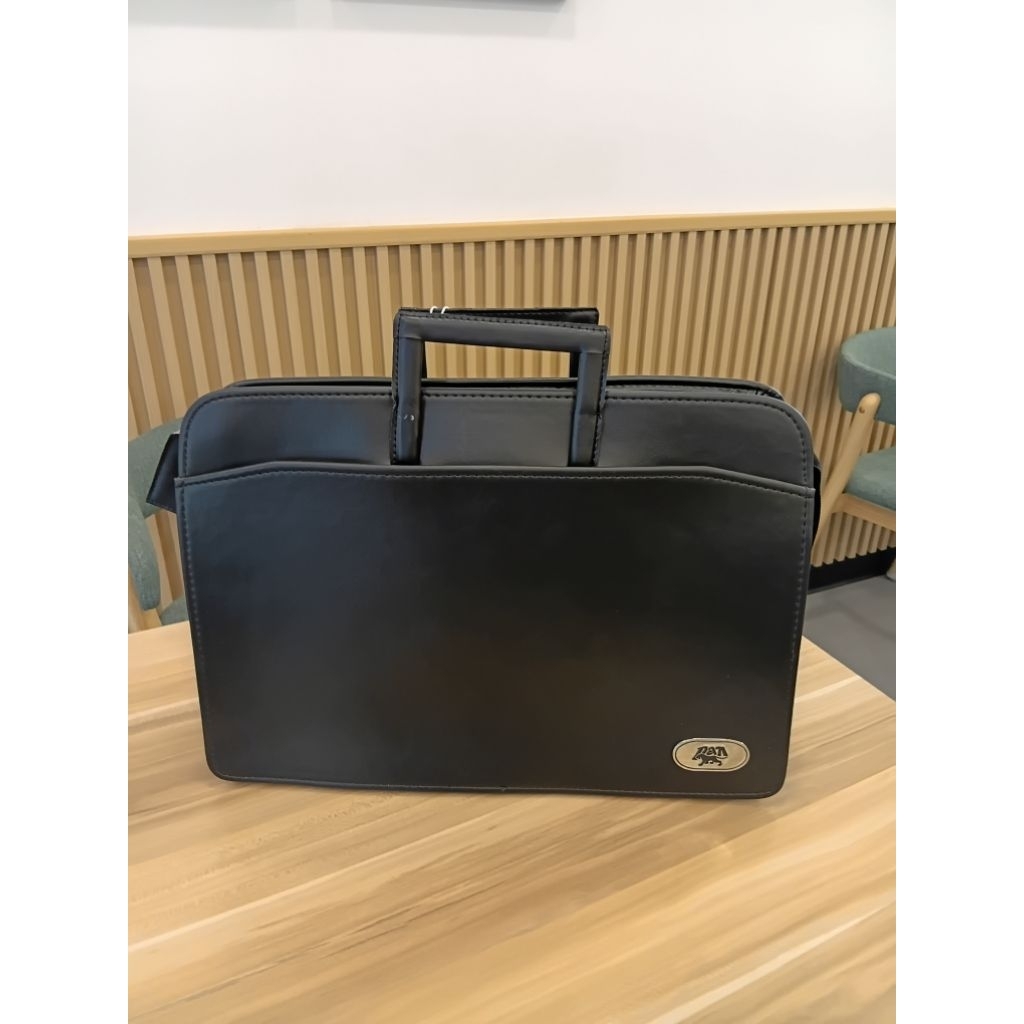 กระเป๋าหนังสีดำอย่างดีของPanใช้ใส่เอกสารหรือเป็นกระเป๋านักเรียน