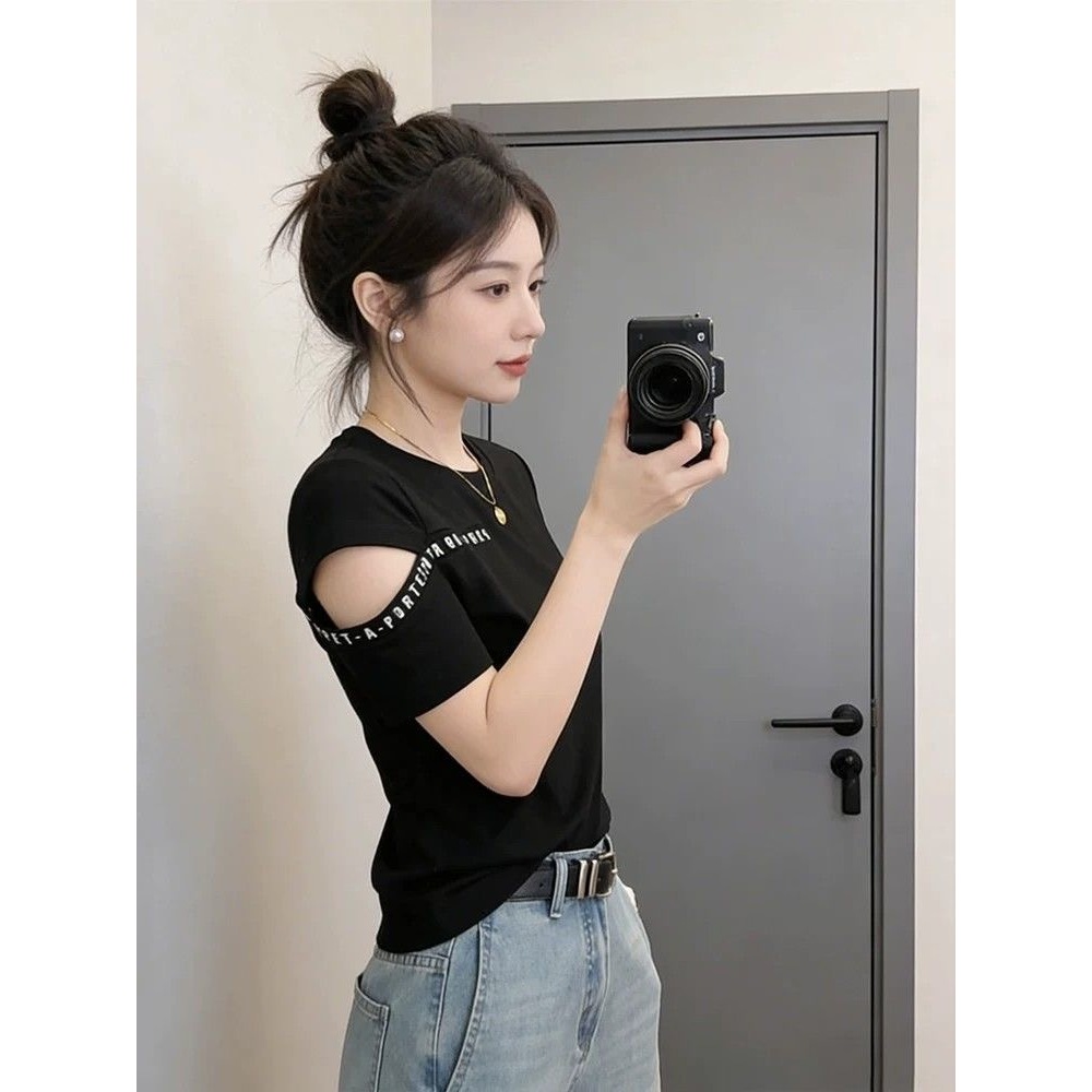 เสื้อยืดฤดูร้อนสำหรับผู้หญิงที่มีดีไซน์เก๋ไก๋และเป็นเอกลักษณ์ โดดเด่นด้วยดีไซน์เปิดไหล่และลายกราฟิกตัวอักษร เป็นเสื้อที่