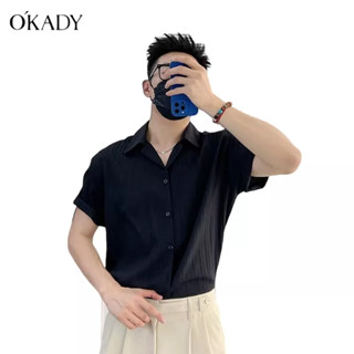 OKADY เสื้อเชิ้ตแขนสั้นลายทางแนวตั้งคุณภาพสูงสไตล์เกาหลีสำหรับผู้ชายเสื้อเชิ้ตแขนสั้นหลวมสบาย ๆ