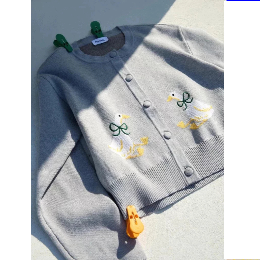 [Pomelo] เสื้อคาร์ดิแกนซิกเนเจอร์ถักแขนยาวทรงครอปคอกลมกระดุมหน้าลายเป็ดสีขาวประดับโบว์