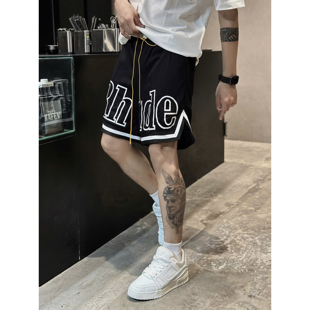 Rhude กางเกงขาสั้นลมผู้ชายสีดําพิมพ์ตัวอักษรสีขาวและเย็บปักถักร้อยลายสีดําและสีขาวพร้อม Hem Tube กาง